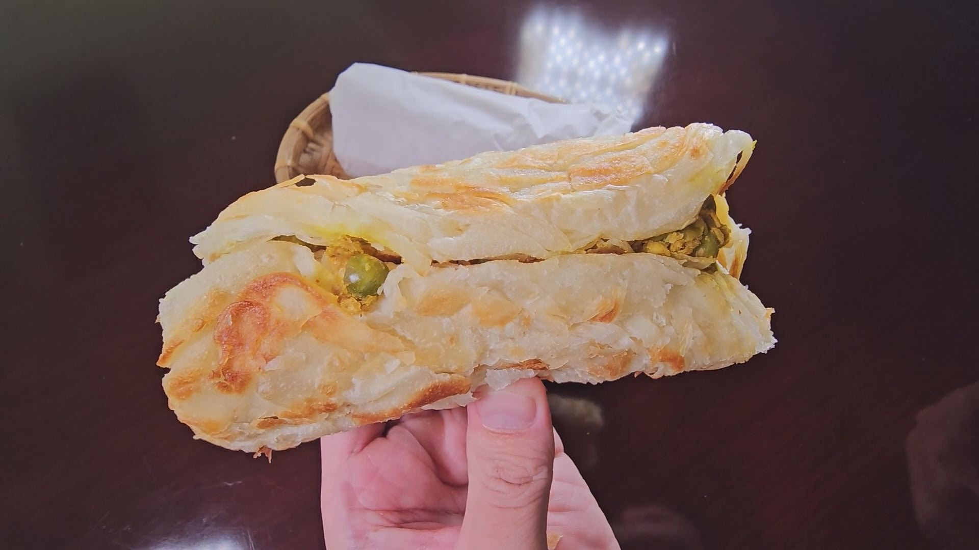 軟中帶Q的層層麵香，香酥不會油膩，包進香辣多汁的打拋雞，層次很豐富。（記者吳承恩／攝影)